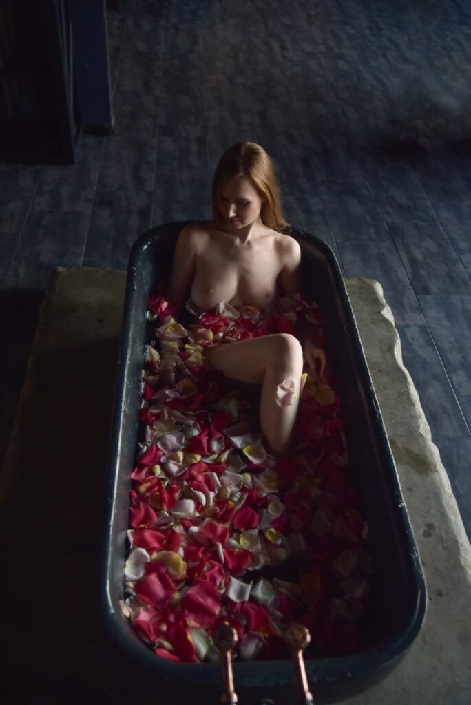 Nude in her bathtub.