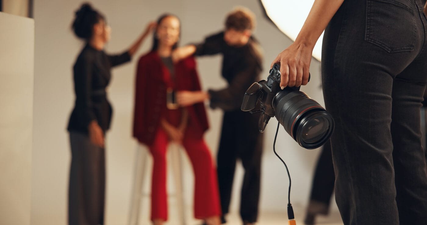 Hands, photographer and people in backstage, camera and pictures for fashion magazine and studio. P.