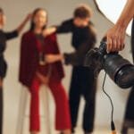 Hands, photographer and people in backstage, camera and pictures for fashion magazine and studio. P.