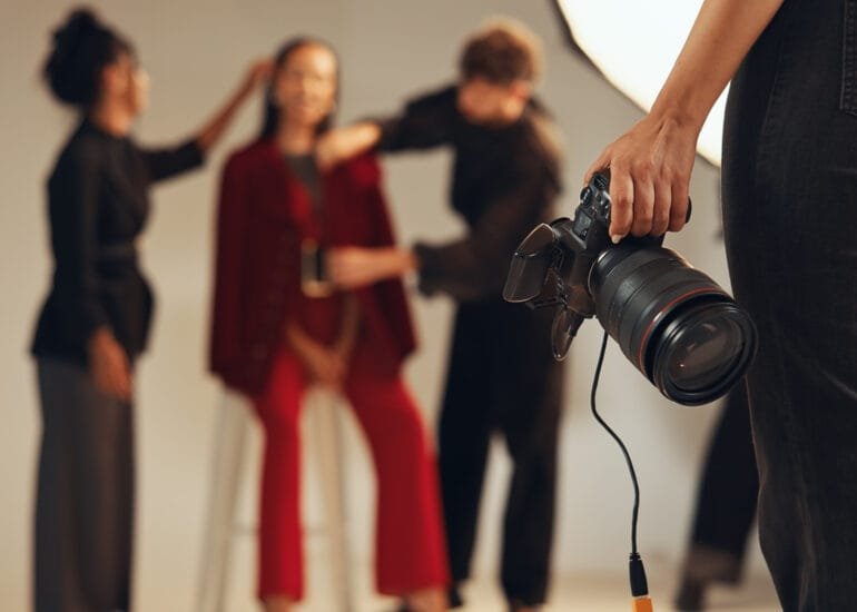 Hands, photographer and people in backstage, camera and pictures for fashion magazine and studio. P.