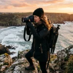 Photographer working on location at dawn on a coastal cliff